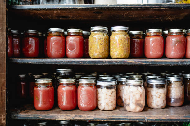 Masson jars lined up in a pantry using mason jar lids.