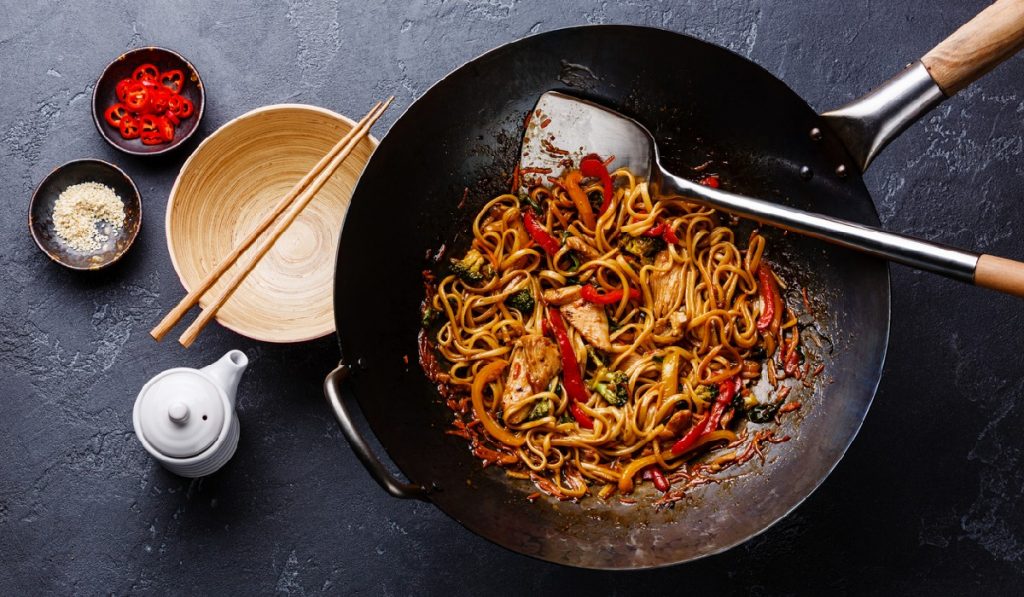 using a carbon steel wok to prepare stir fry noodles