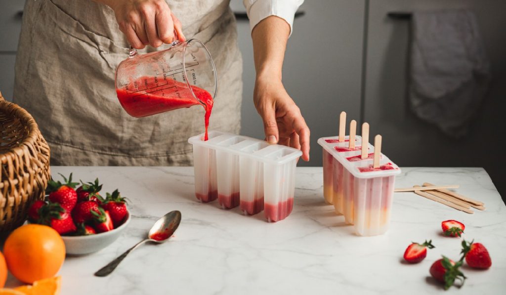 pouring your recipe into your popsicle molds