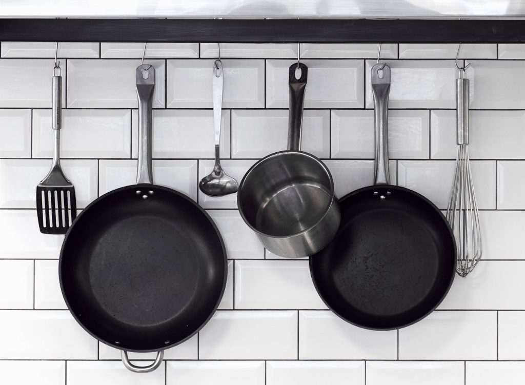 Pots, pans, and cookware hanging on a wall