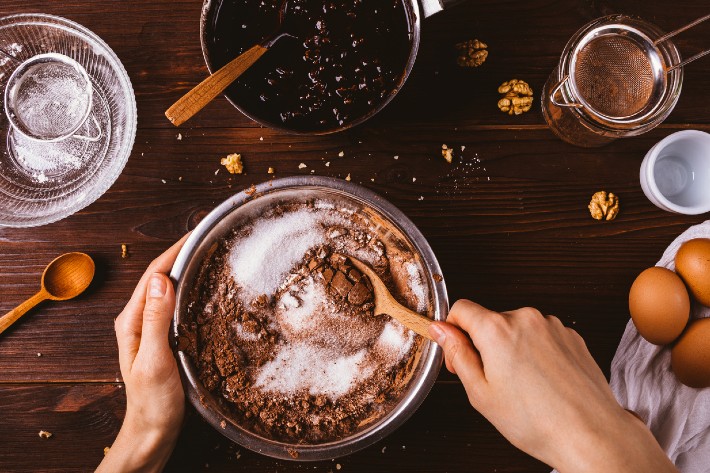 A person stirs a bowl of cookie mix, preparing to bake with one of the best cookie mix options available.