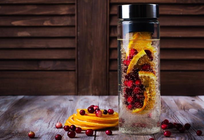 A water infuser filled with water and an assortment of fruit.